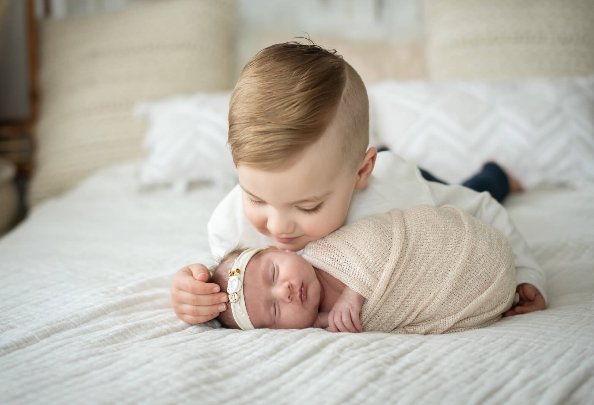 little boy kissing his newborn sister on the cheek Edmonton Baby Stores