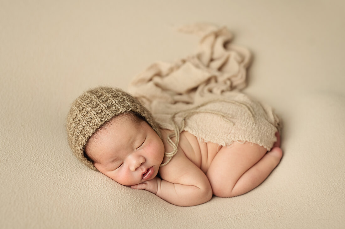 Newborn baby boy in a neutral knit bonnet
